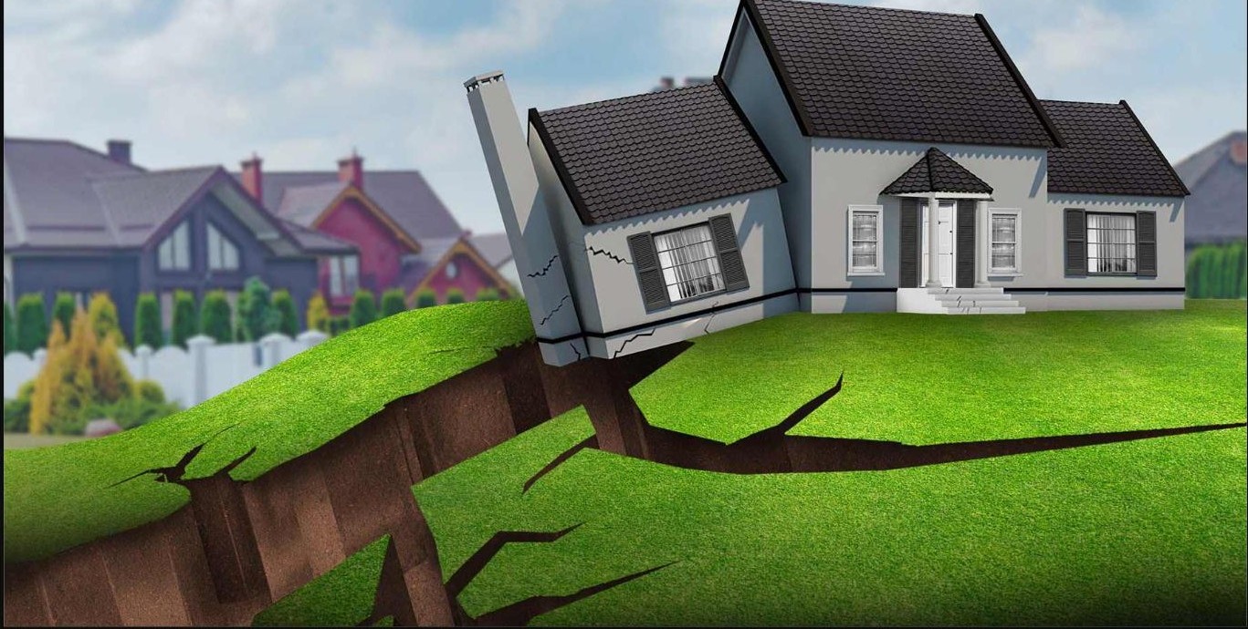 A house settling and cracking above a widening crack in the yard