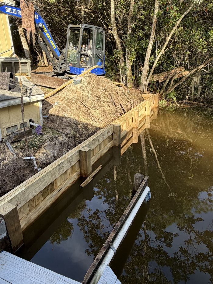Solid Foundations crew excavating for a new seawall along a residential canal