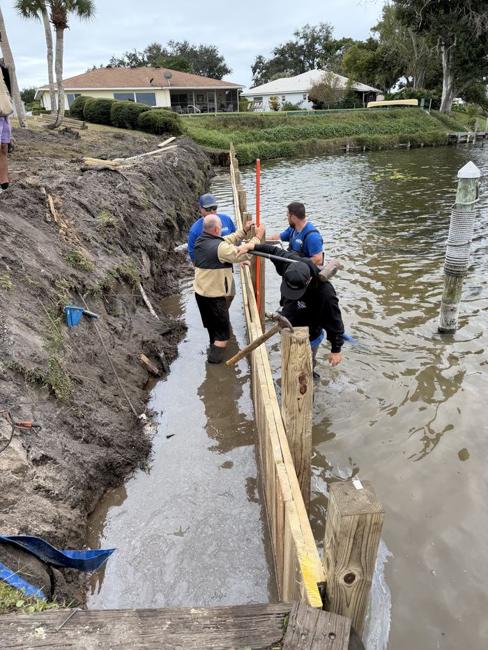 Solid Foundations crew setting seawall pilings at the waterline