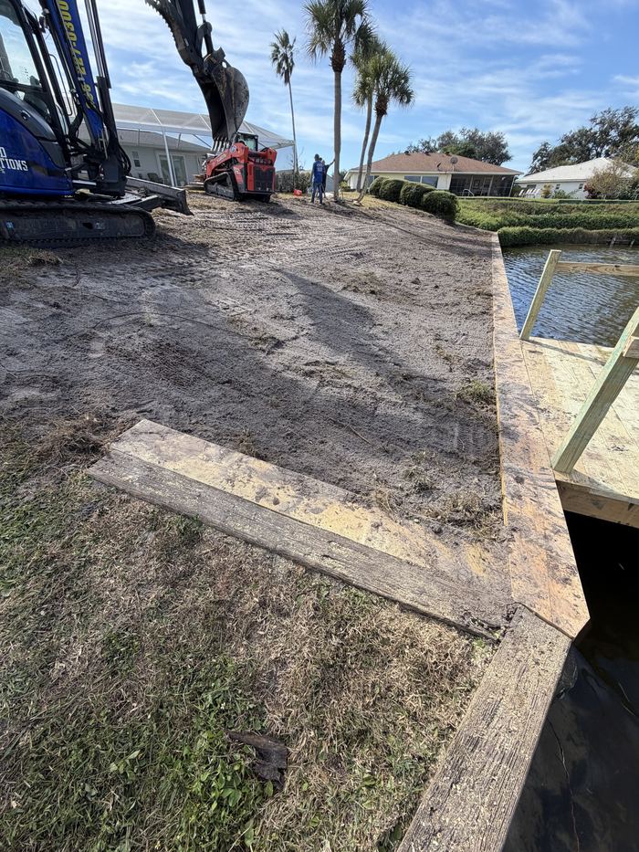 Solid Foundations excavation equipment staged beside a new seawall and dock