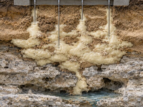 Cutaway illustration of polyurethane grout injected into limestone bedrock to fill voids and stop water intrusion