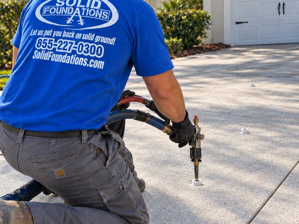 Solid Foundations technician preparing a void filling injection on a residential driveway