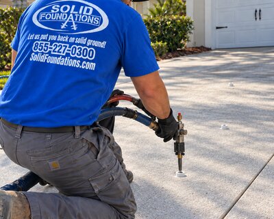 Solid Foundations technician preparing a void filling injection on a residential driveway
